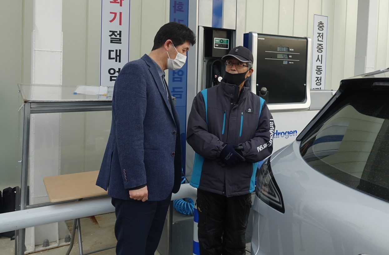 사진2. 정경윤 한강유역환경청장(왼쪽)이 관계자에게 수소자동차 충전 방법에 대한 설명을 듣고 있다.